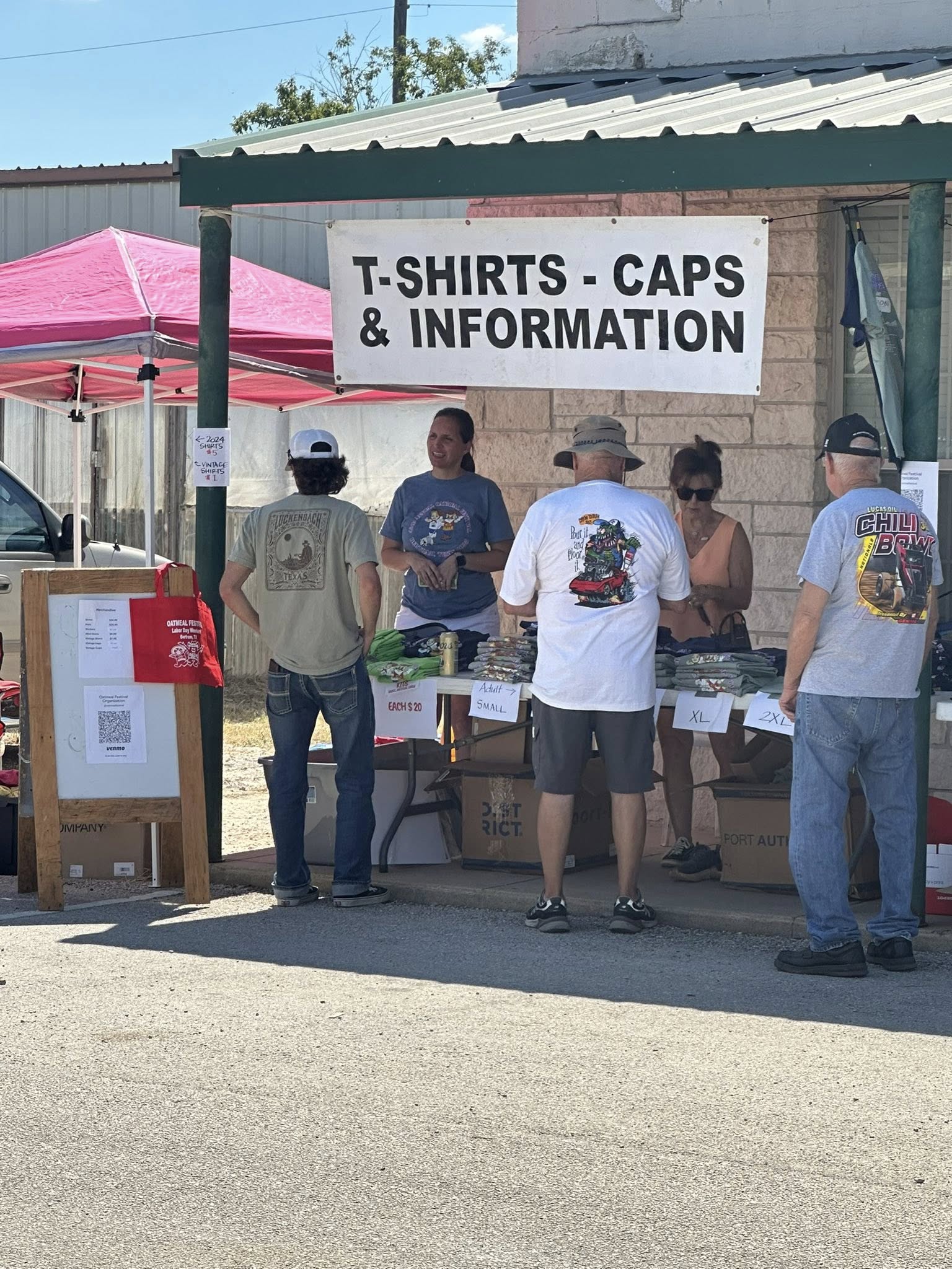 Youth volunteer staffing a booth at the Oatmeal Festival in downtown Bertram Texas